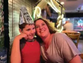 Robin Suzelis and her son wearing a "Happy New Year" hat.