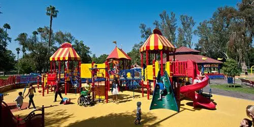 Colorful carnival-themed playground with accessible play structures.