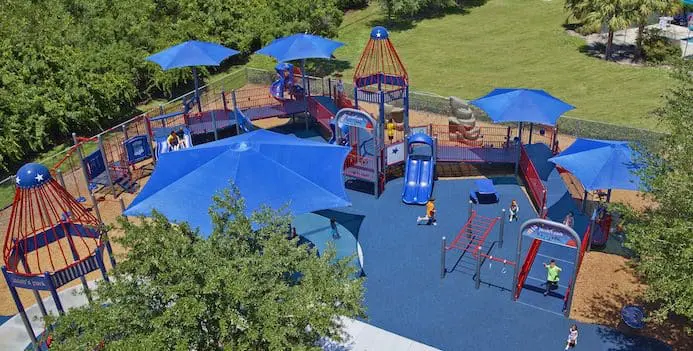 Jacob's Park playground in Boynton Beach, Florida, with blue sunshades and colorful play structures.