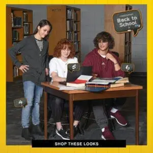 Three students sit at a table with a laptop and books, a "Back to School" sign hangs in the background.
