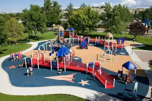 Rocket Park playground with red, blue, and tan equipment and star-shaped pathways.