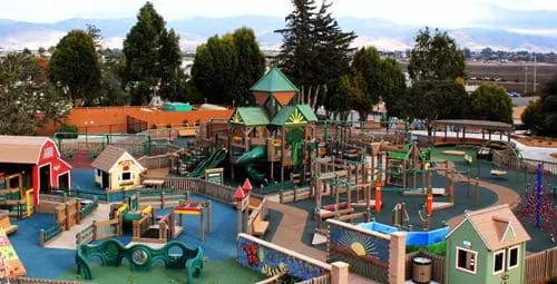 A spacious playground with multiple play structures and themed playhouses.