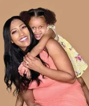 Indigo Abell with her daughter piggyback riding.