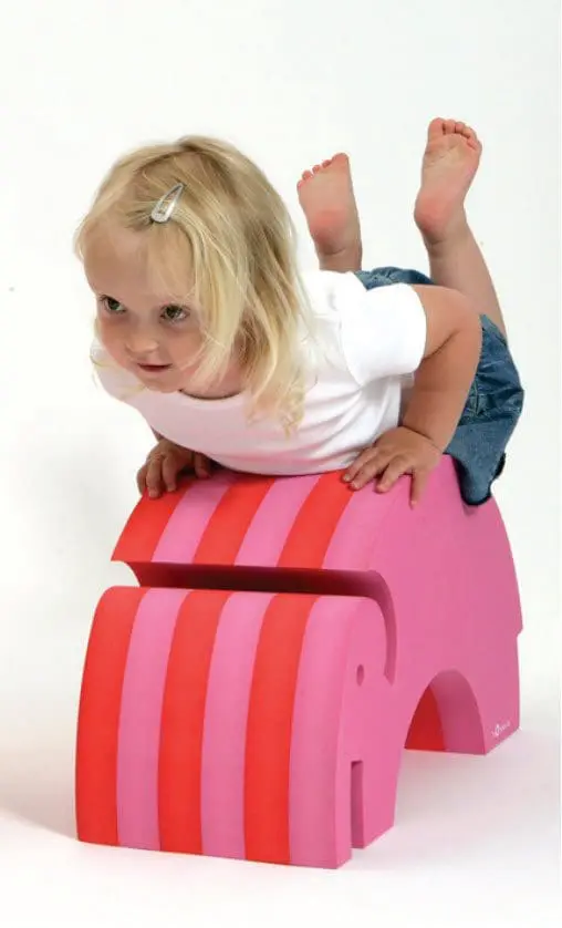 A child climbs on a pink and orange striped Bobles Tumbling Elephant.