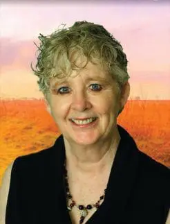 Patricia E. Bailey smiling, wearing a black top and a beaded necklace.