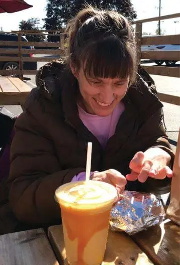 Sarah Goll smiling at a table outdoors.