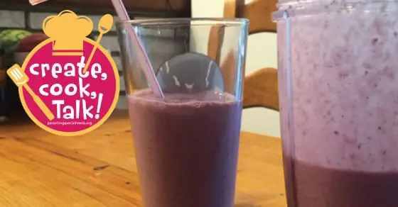 Two glasses of purple smoothie sit on a wooden table next to a circular graphic with a chef's hat and the words "create, cook, Talk!