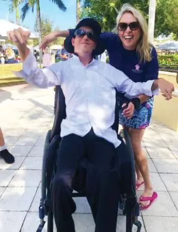 Lisa Lupi and JC in wheelchairs outdoors.