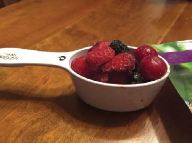 Measuring cup filled with frozen berries