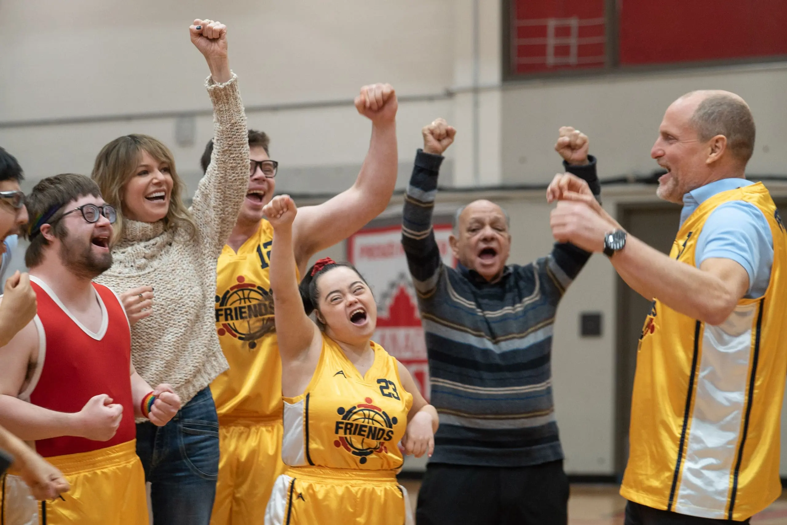 The cast of Champions celebrates on a basketball court.