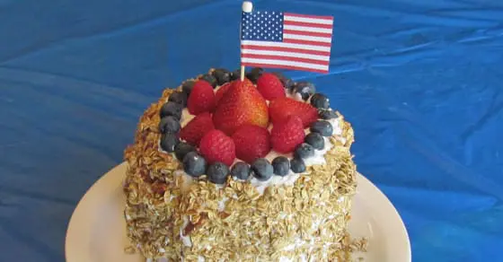 Cake topped with berries and a small American flag.