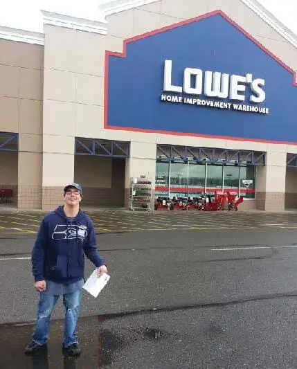 Man standing in front of a Lowe's store.