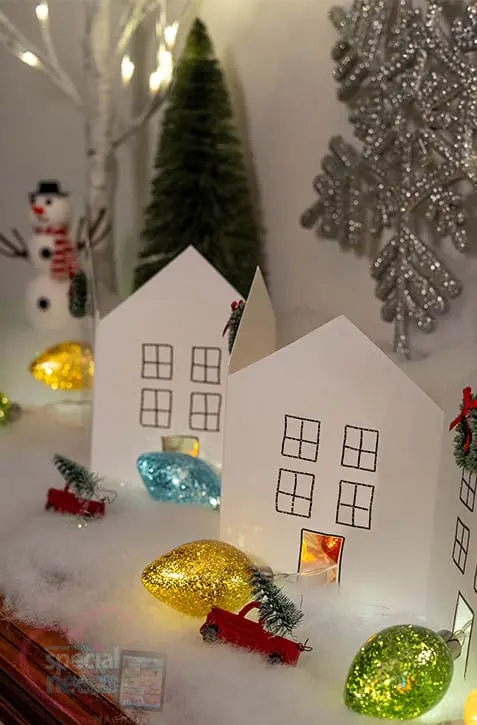 Paper chain houses and Christmas decorations creating a winter village scene.