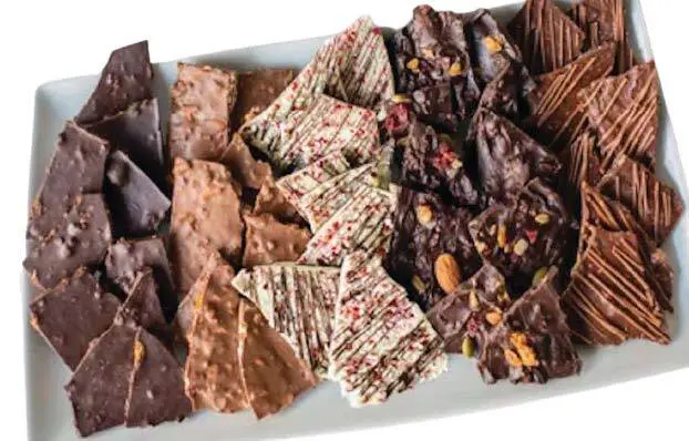 Assortment of chocolate bark pieces on a white platter