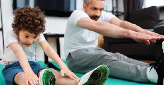 Man and child stretching on exercise mats