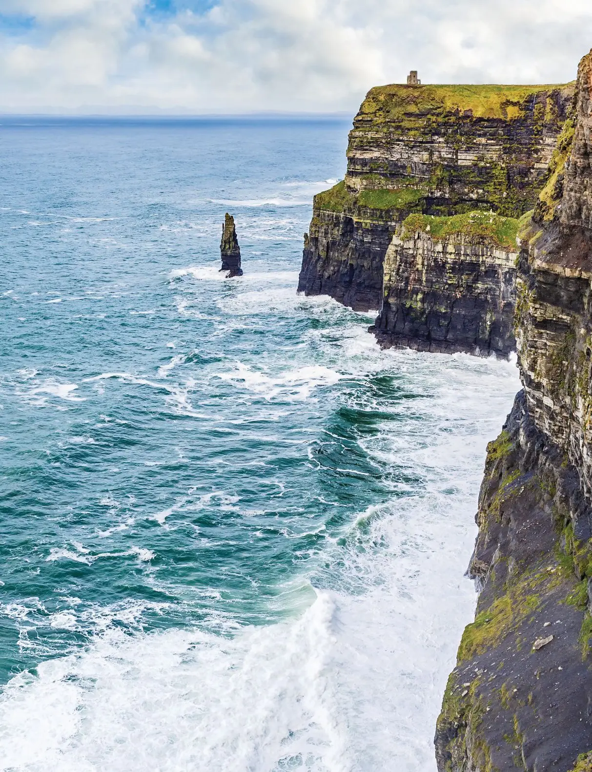 Cliffs of Moher with waves crashing against them.