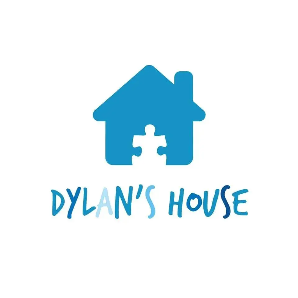 Logo for Dylan's House featuring a blue house icon with a puzzle piece cut out, and the words "DYLAN'S HOUSE" below.