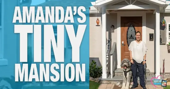 Amanda stands with a dog in front of her "Tiny Mansion.