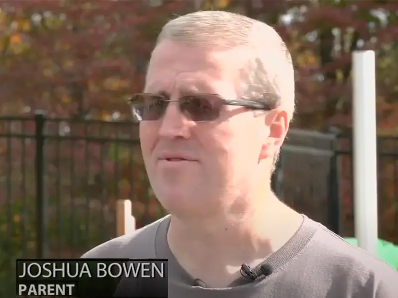 Joshua Bowen, parent, speaking outdoors.