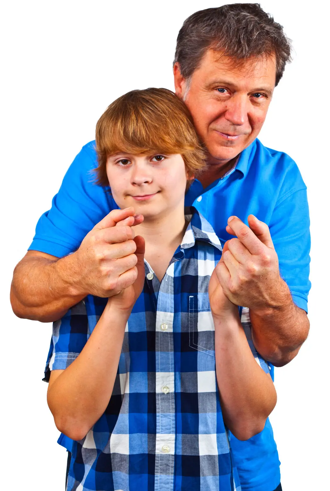 An adult standing behind and embracing a youth, both holding their hands together in front of them.