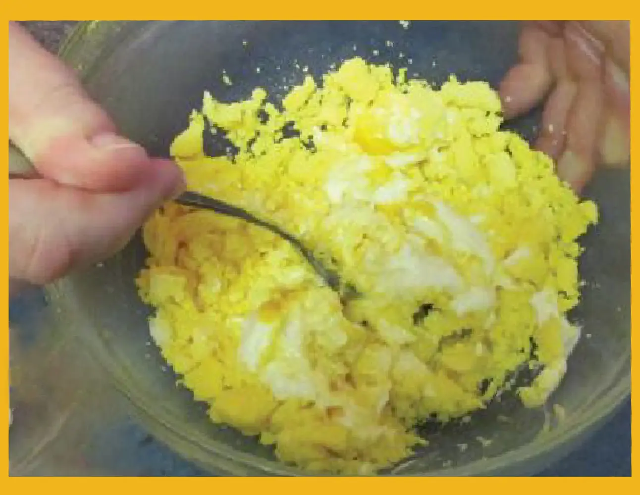 Chopped hard-boiled egg yolks and whites being mixed in a bowl