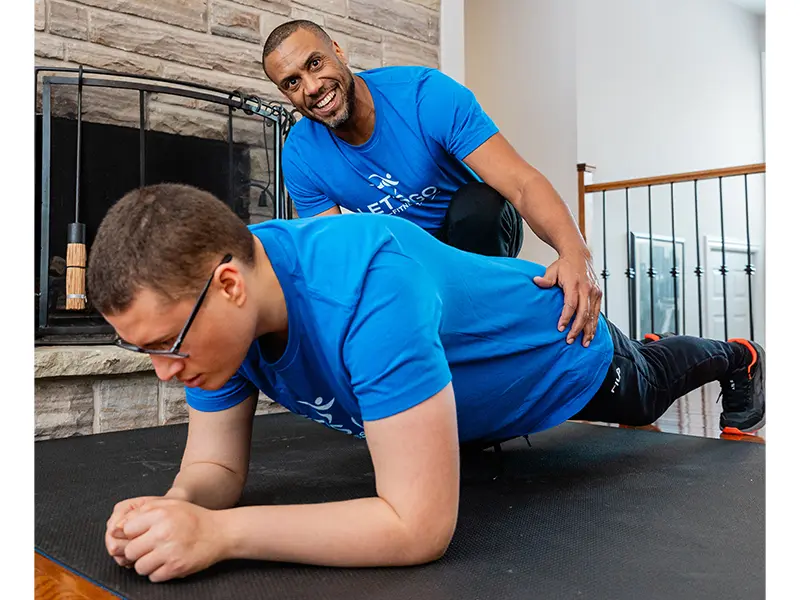 Keegan Johnson assists his son Dante with a plank exercise.