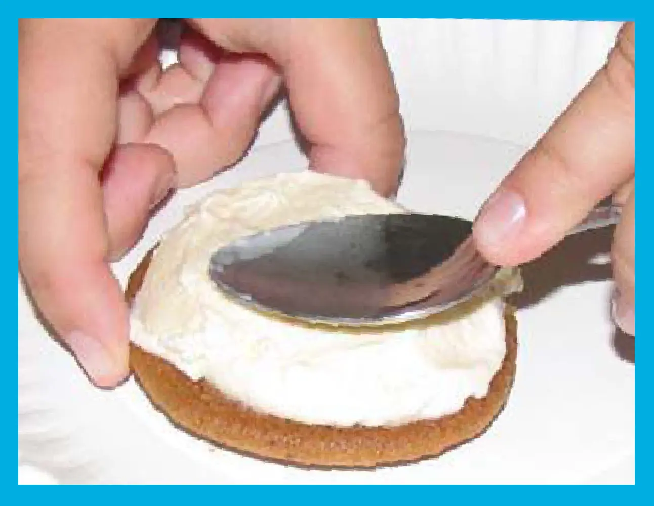 Spreading vanilla ice cream onto a cookie for an ice cream sandwich.