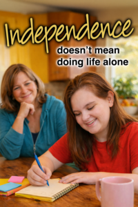 A woman smiles as a girl writes in a notebook at a table.