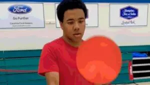 A person is shown practicing a pickleball skill for beginners.