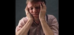 Man with hands on head looking distressed.