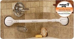 White shower grab bar with suction cups mounted to tiled wall near shower controls.