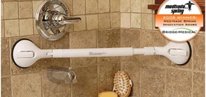 White shower grab bar with suction cups mounted to tiled wall near shower controls.