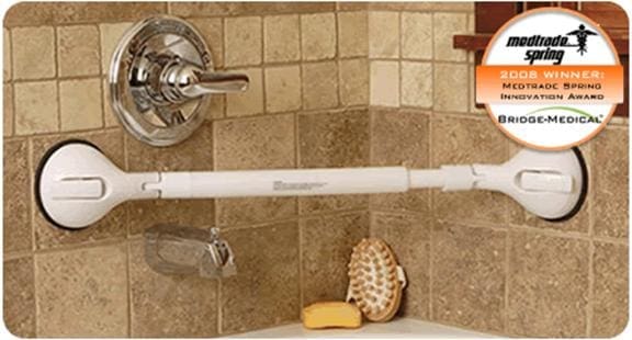 White shower grab bar with suction cups mounted to tiled wall near shower controls.