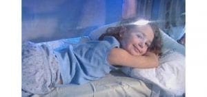 Child resting inside a hyperbaric oxygen chamber.
