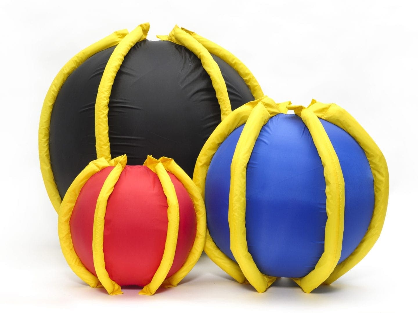 Three inflatable balls in red, blue, and black with yellow ribbing.