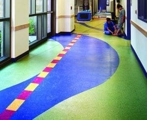 Classroom hallway with colorful, wavy floor design and two people in the background.