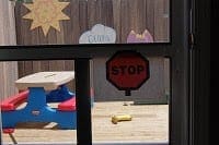Stop sign and sun cutout on window above children's play table