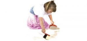 Young girl sweeping with a dustpan and brush.