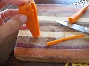Carrot pieces are prepared on a cutting board for a recipe.