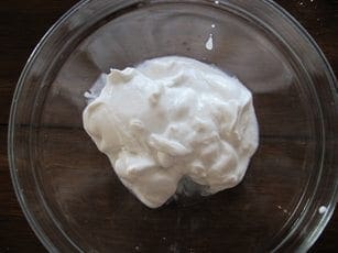 Whipped coconut milk mixture in a glass bowl for a recipe.