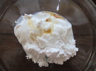 Coconut milk, powdered sugar, and vanilla extract in a bowl for a silly creature recipe.