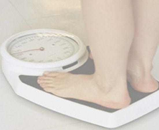 Feet on a white analog scale.