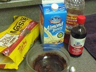 Chocolate fondue ingredients including chocolate chips, almond milk, honey, and vanilla extract.