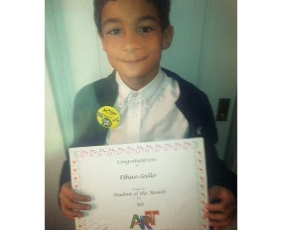 Ethan Gallo smiling with his Student of the Month award.