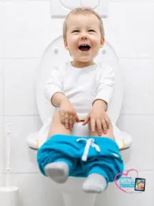 Happy toddler sitting on a toilet with pants down.