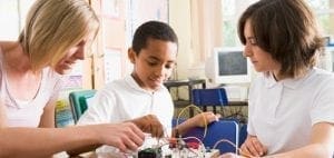 Teacher and two students working on an electronics project.