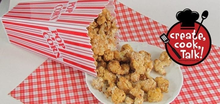 Cheesy" cauliflower popcorn spills out of a popcorn box onto a plate.