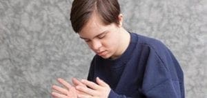 Teenager with hands clasped together.