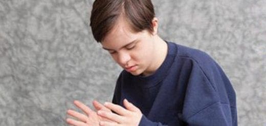 Teenager with hands clasped together.