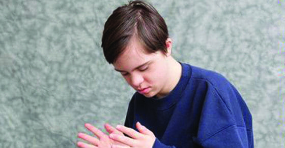 A young person looks down at their hands.